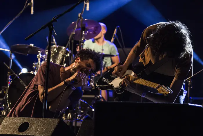 Banda a tocar em palco, sob luz quente