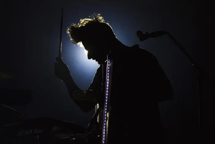 Silhueta de músico em palco, em contraluz